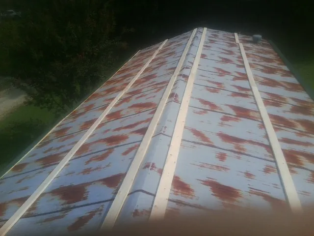Rusted metal roof panels with new wood purlins before replacement — Storm Damage Roof Repair in Greenhurst by Roofing Brothers