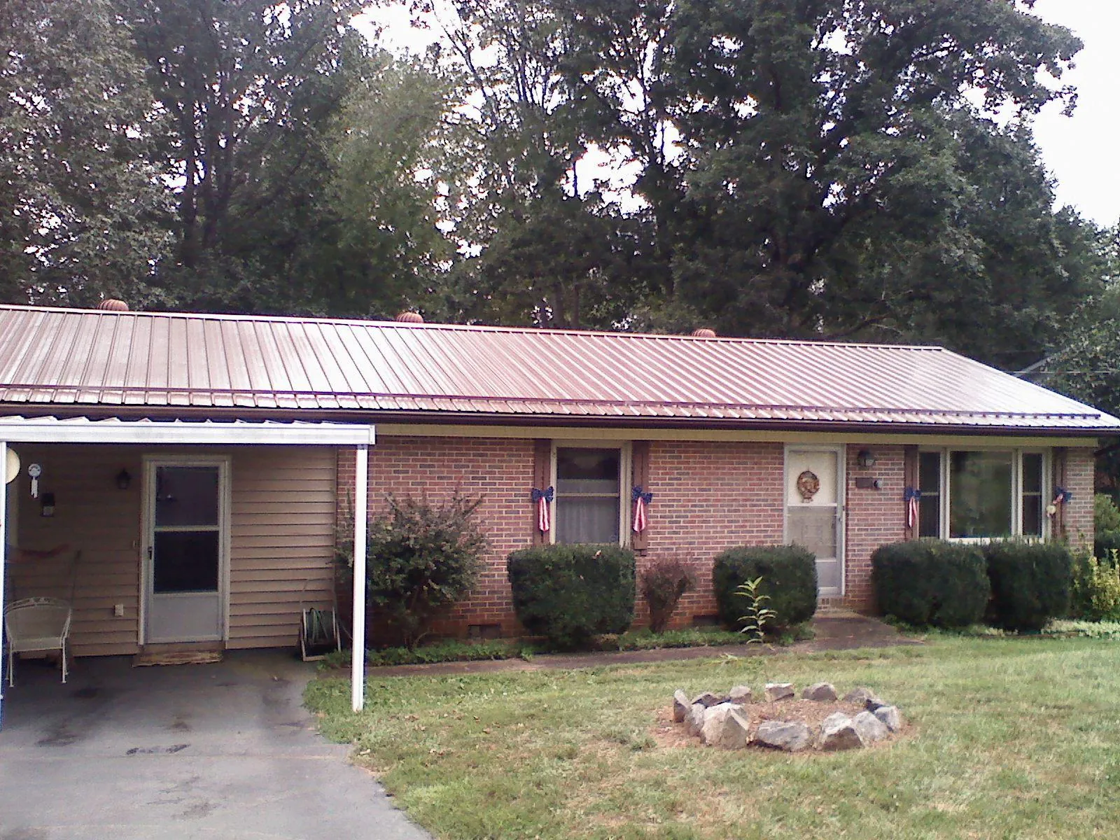 Bronze metal roof and carport on a brick ranch home — Roof Repair work by our crew in Greenhurst